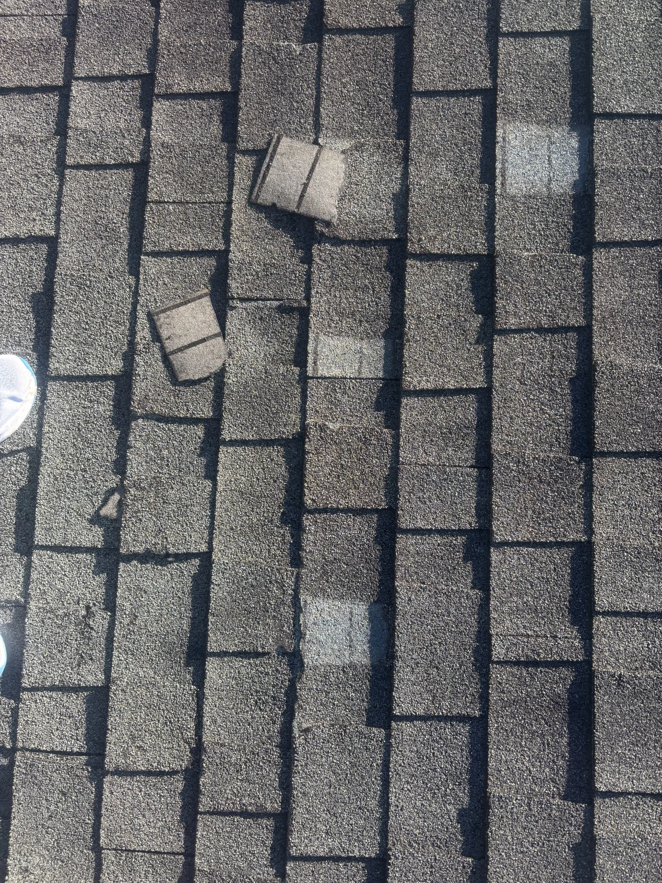 Missing shingles documented on a storm-damaged roof in Eunice, LA